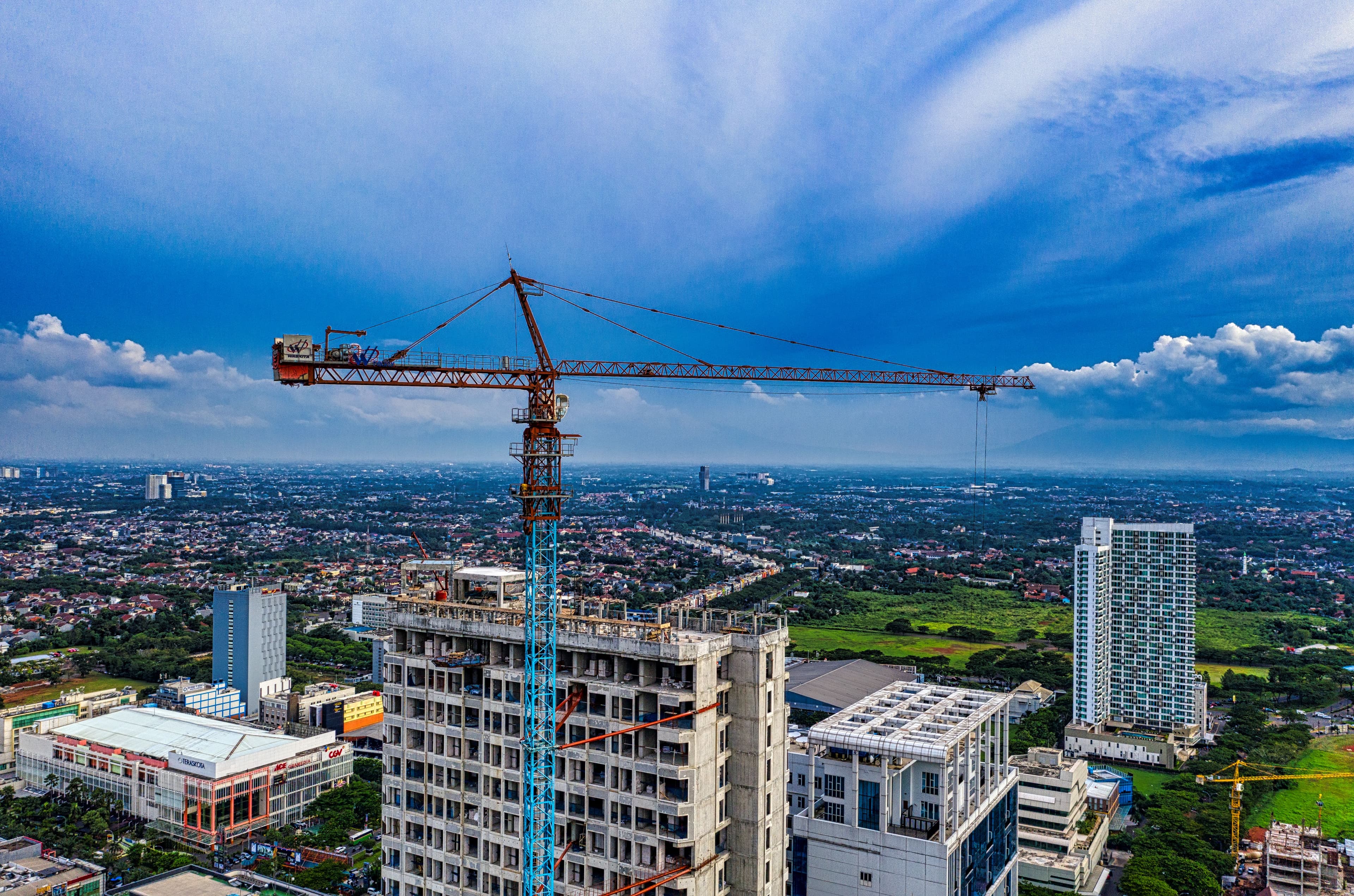 Vista aérea de obra com gruas em área urbana